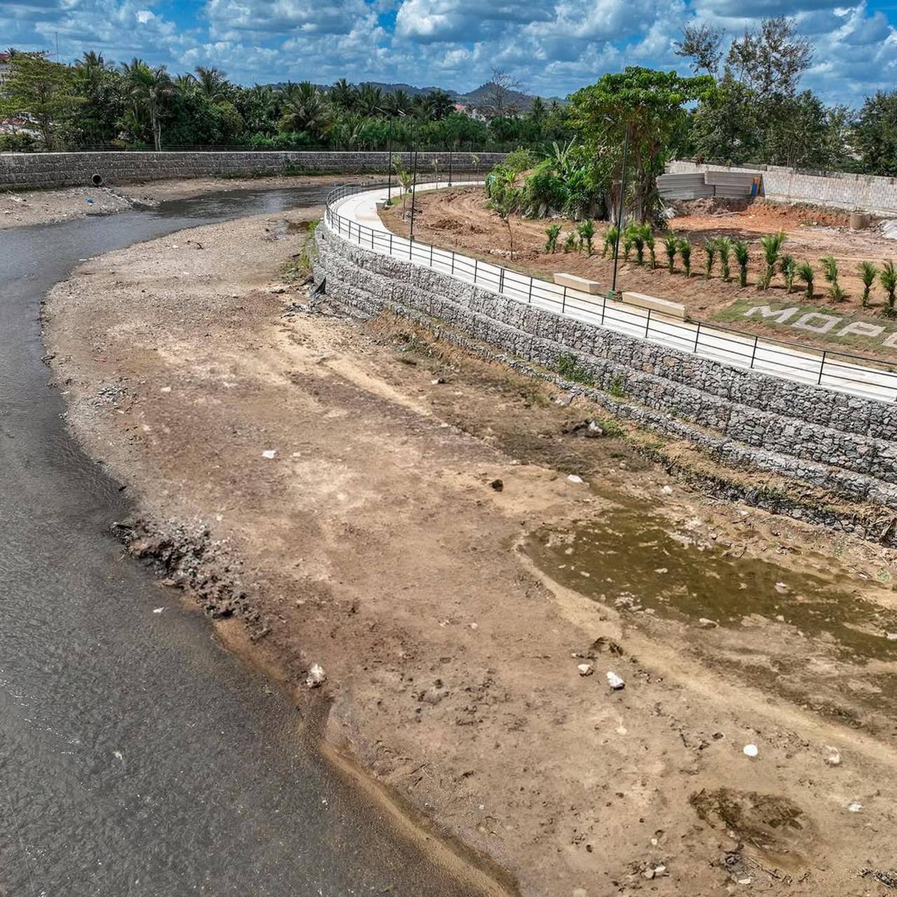 Muro curvo de gaviones con paseo peatonal